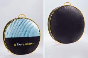 29519 - Сумка - саквояж для изделий из текстиля с кедерной окантовкой сшитая по форме приплюснутого цилинда, лицевая сторона сумки состоит из пленки ПВХ  в верхней части для обзора упакованных в сумку изделий и нетканного материала в нижней части с нанесенным на нем логотипом компании заказчика.