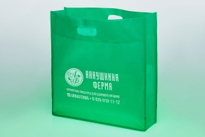 s39 - Зеленая обьемная промосумка с белым логотипом и вырубными ручками из спанбонда.